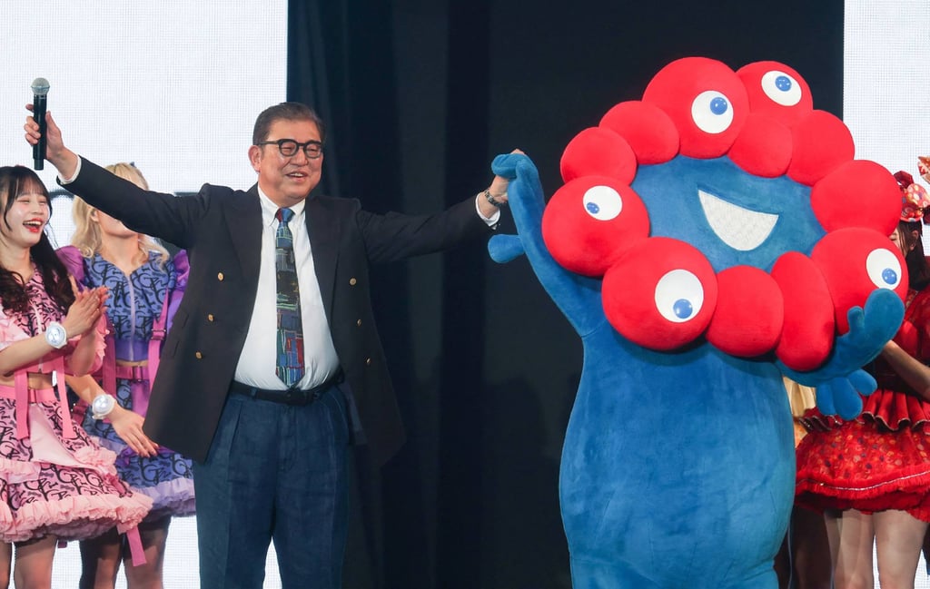Japanese Prime Minister Shigeru Ishiba stands with Myaku-Myaku (right), the mascot for the 2025 Osaka World Expo, at the Tokyo Girls Collection fashion event on Saturday. Photo: Jiji Press/AFP