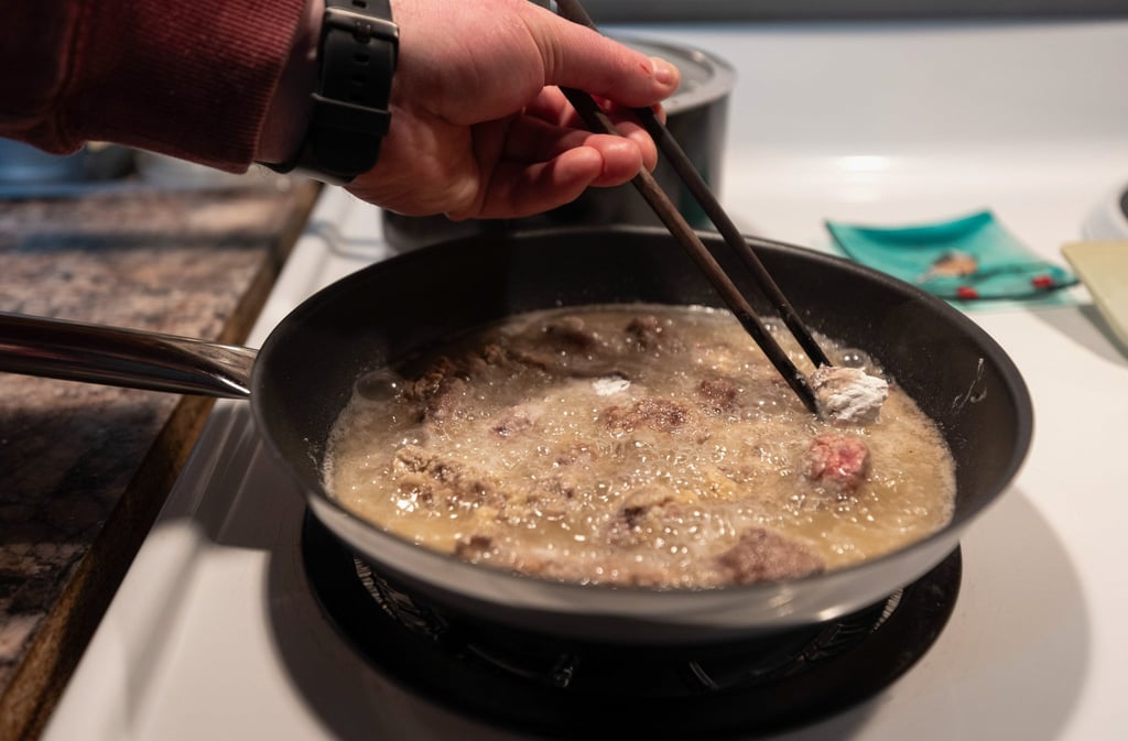 Matthew Bossons adds spruce grouse to a frying pan in preparation for a localised rendition of a sweet and sour pork dish. Photo: Crystal Schick