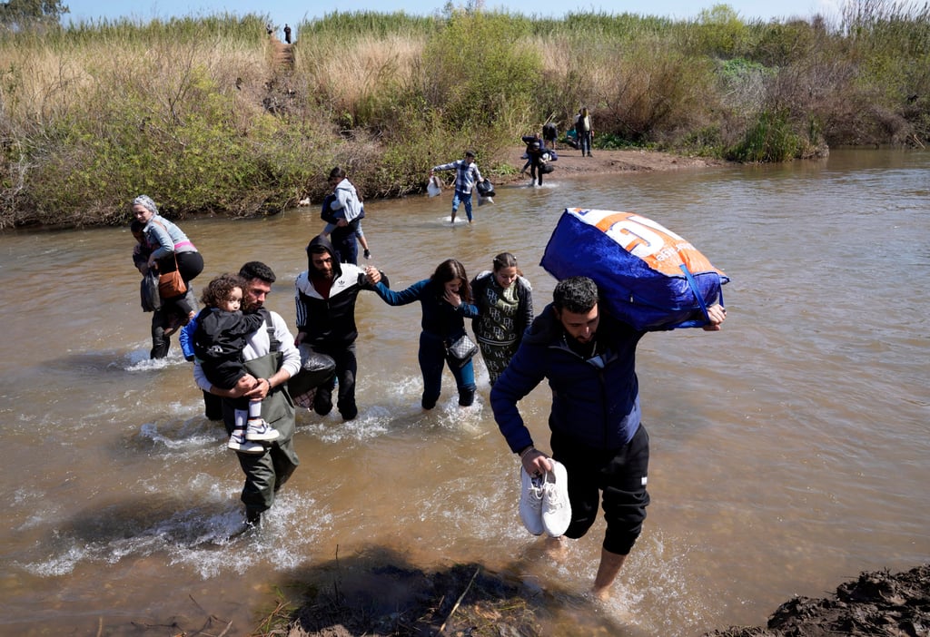 Syrian families who fled clashes in Syria cross a river marking the border between Syria and northern Lebanon. Photo: AP Syrian families who fled clashes in Syria cross a river marking the border between Syria and northern Lebanon. Photo: AP