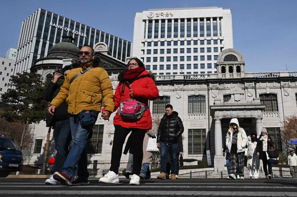 Pedestrians cross a road in front of the Bank of Korea headquarters in Seoul. South Korea reported a record number of foreign residents last year, but many face economic struggles and education cost burdens amid rising living expenses. Photo: AFP