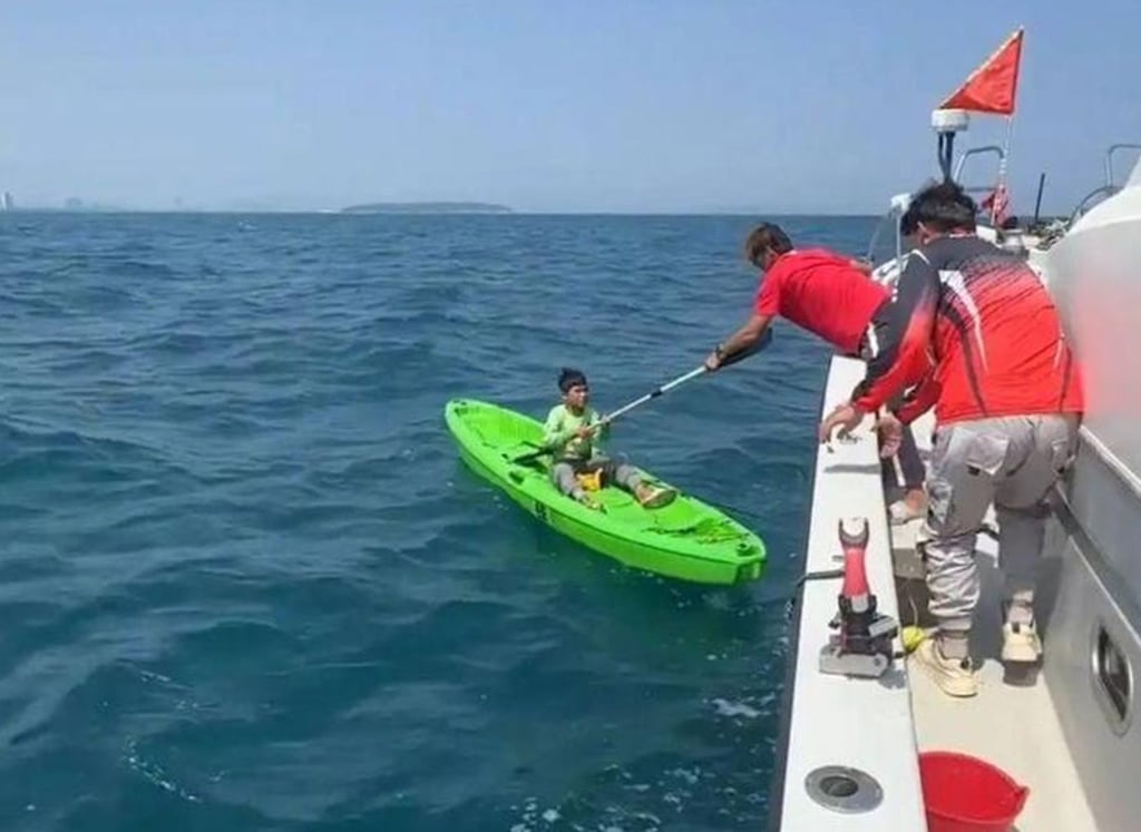 Rescuers bring the boy, and the boat he took, to safety after 24 hours adrift at sea. Photo: 163.com