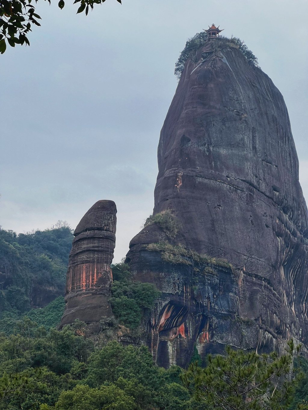 Yangyuanshi, or “Male Stone” (above left), and the mountain peak. topped by a pavilion, from which it was separated by tectonic forces over thousands of years. Photo: Xinyi Wu Yangyuanshi, or “Male Stone” (above left), and the mountain peak. topped by a pavilion, from which it was separated by tectonic forces over thousands of years. Photo: Xinyi Wu