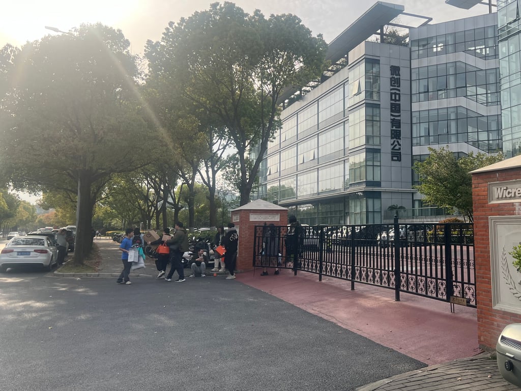 周一，被解雇的 Wicresoft 员工带着他们的个人物品搬出了位于上海闵行区的公司办公楼。摄影： Ann Cao
