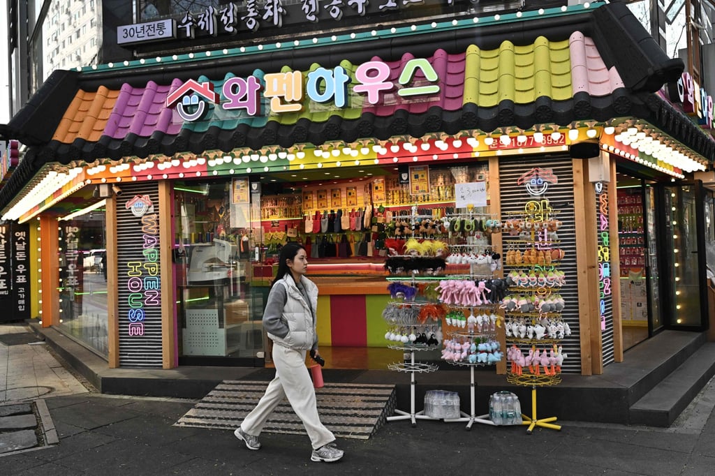 A woman walks past a souvenirs shop in a tourist area in Seoul. Loneliness-driven businesses are closely associated with a fast-growing number of single-person households in South Korea. Photo: AFP