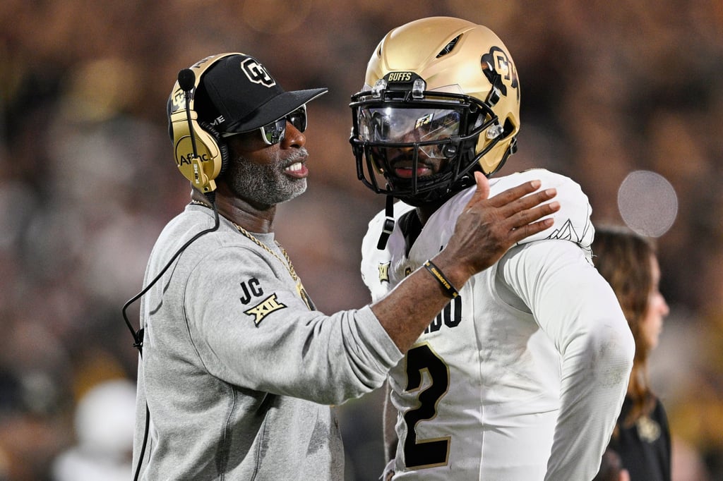 Colorado coach Deion Sanders (left) with quarterback son Shedeur in an NCAA game last September. Photo: AP