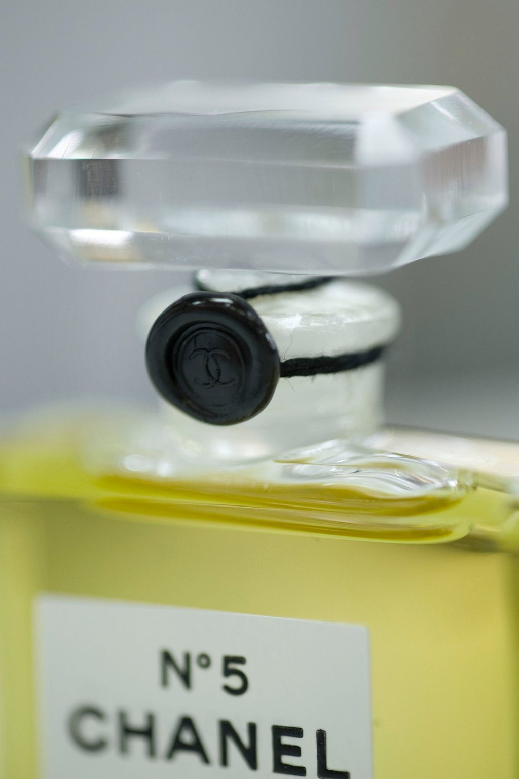 Cada frasco No 5 é selado com um baudruche: um delicado filme natural preso com dois fios de fio de algodão preto pérola e um carimbo de cera com o logotipo Chanel duplo C. Foto: Apostila Cada frasco No 5 é selado com um baudruche: um delicado filme natural preso com dois fios de fio de algodão preto pérola e um carimbo de cera com o logotipo Chanel duplo C. Foto: Apostila