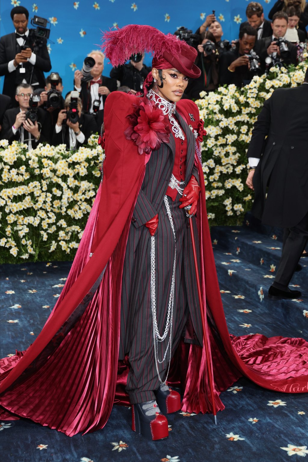 Teyana Taylor poses on the red carpet for the 2025 Met Gala in a zoot suit look with a red, feather-adorned top hat and a huge matching cape. Photo: EPA-EFE Teyana Taylor poses on the red carpet for the 2025 Met Gala in a zoot suit look with a red, feather-adorned top hat and a huge matching cape. Photo: EPA-EFE