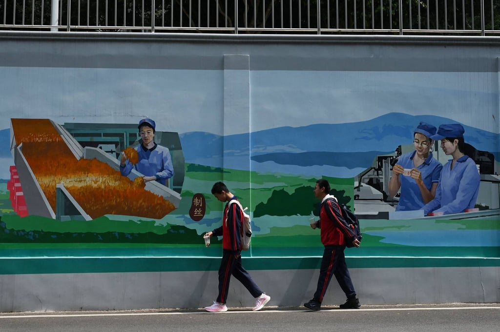 Students walk past a mural of workers at a cigarette factory on a wall in Yuxi, in Chinaโs Yunnan province. Photo: AFP Students walk past a mural of workers at a cigarette factory on a wall in Yuxi, in Chinaโs Yunnan province. Photo: AFP