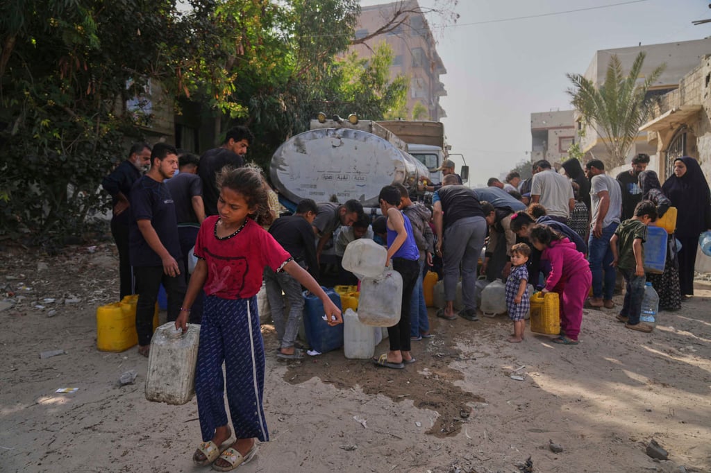 Palestinians collect water in jerrycans at a distribution point west of Gaza City, on Sunday. Photo: AP Palestinians collect water in jerrycans at a distribution point west of Gaza City, on Sunday. Photo: AP