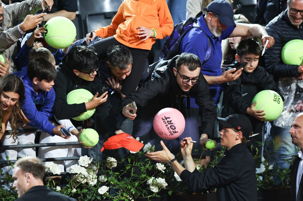 Jannik Sinner (bottom right) signs autographs for fans in Rome. Photo: Xinhua