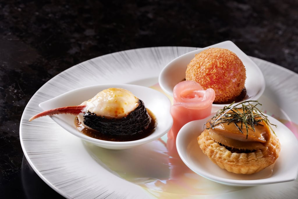 A dim sum platter that changes with the seasons, Lai Ching Heen’s Three Trios currently features a crispy lobster ball, wok-seared crab claw and baked abalone with eel and seaweed. A dim sum platter that changes with the seasons, Lai Ching Heen’s Three Trios currently features a crispy lobster ball, wok-seared crab claw and baked abalone with eel and seaweed.