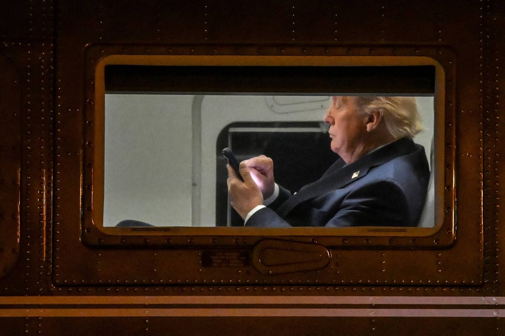 Donald Trump uses a phone on Air Force One. The $TRUMP dinner represents perhaps the boldest commercial venture of his presidency. Photo: AFP Donald Trump uses a phone on Air Force One. The $TRUMP dinner represents perhaps the boldest commercial venture of his presidency. Photo: AFP