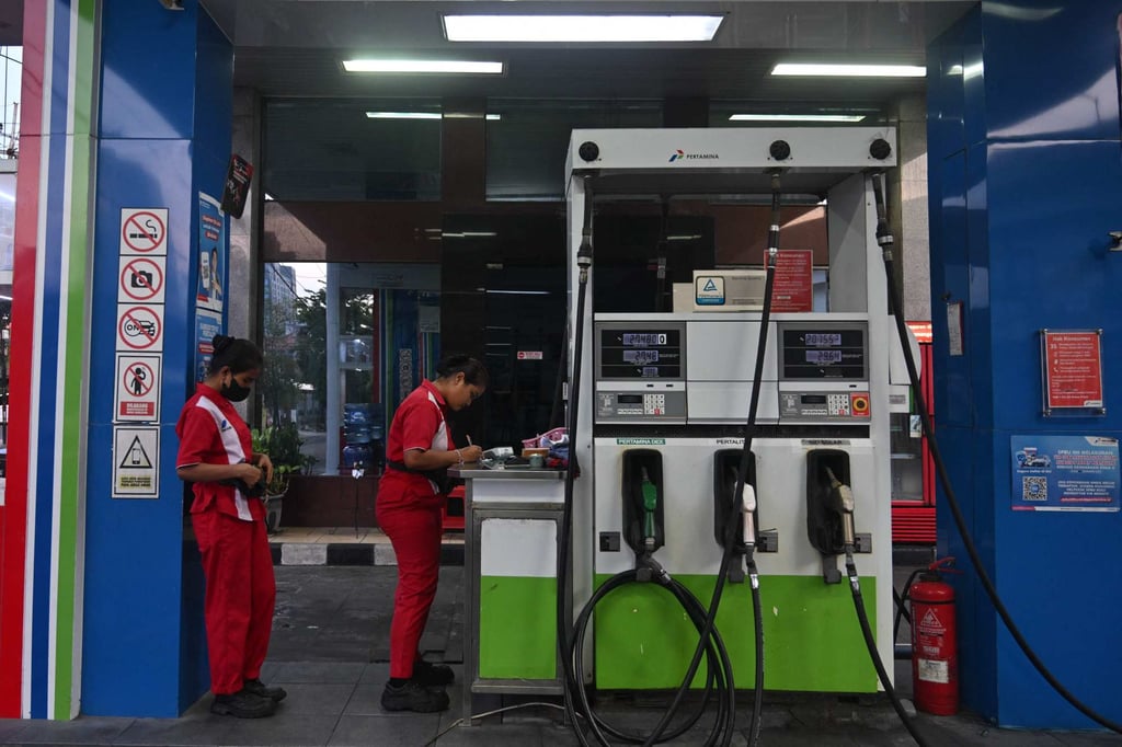 Workers wait for customers at a fuel station of Indonesia’s state-owned oil company Pertamina in Surabaya on March 4, 2025. Photo: AFP