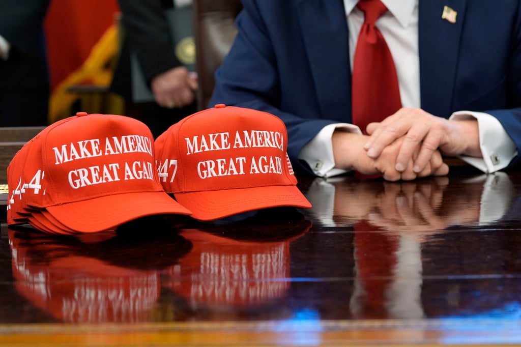 Maga hats are seen on the desk as US President Donald Trump speaks with reporters in the Oval Office in April. Photo: AP Maga hats are seen on the desk as US President Donald Trump speaks with reporters in the Oval Office in April. Photo: AP