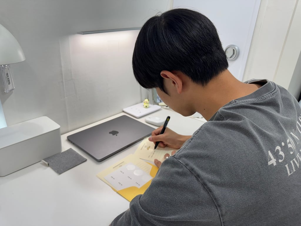 Jeong Seung-won, a 25-year-old university student, writes a response to a letter submitted through the “Warmth Mailbox”. Photo: Lee Seung-ku Jeong Seung-won, a 25-year-old university student, writes a response to a letter submitted through the “Warmth Mailbox”. Photo: Lee Seung-ku