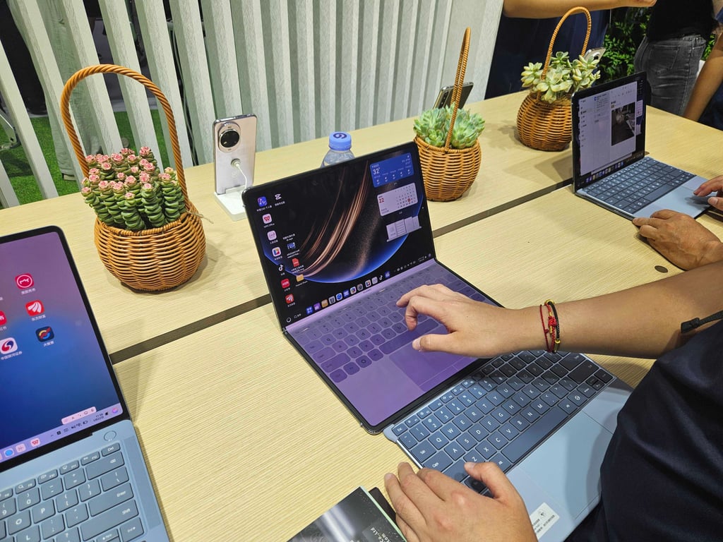 Attendees at the Global AI Device Expo in Shenzhen try Huawei’s new foldable tablet. Photo: Coco Feng
