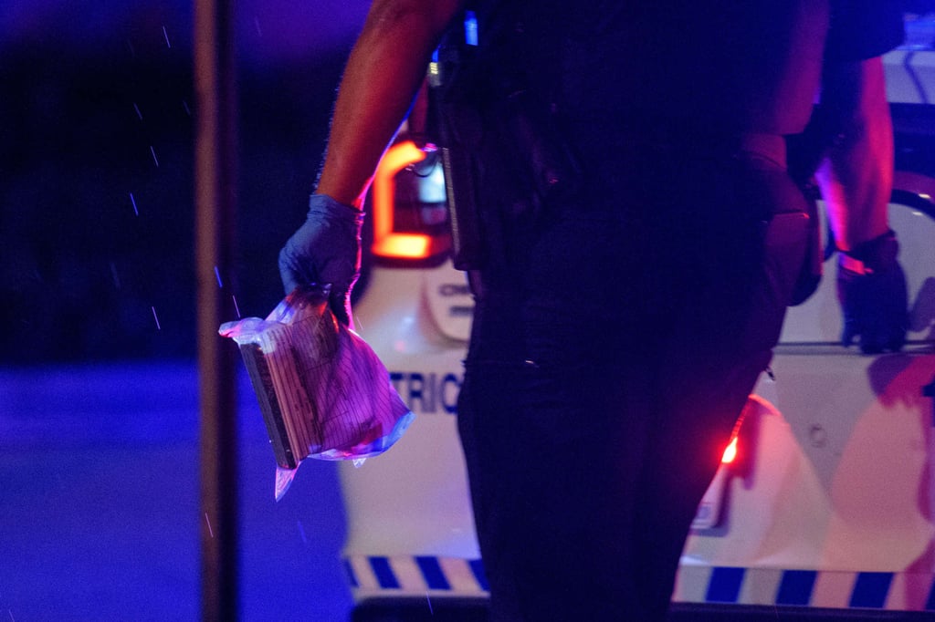 A police officer carries an evidence bag. Photo: AP