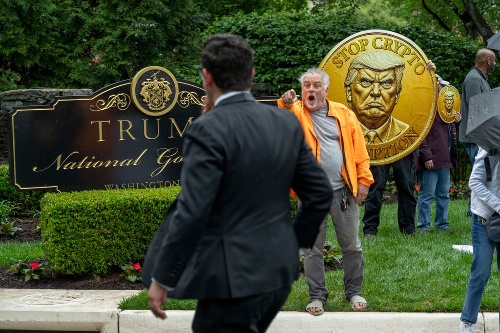 An activist calls out an attendee of an exclusive dinner at Donald Trump’s luxury golf club. Photo: AP An activist calls out an attendee of an exclusive dinner at Donald Trump’s luxury golf club. Photo: AP