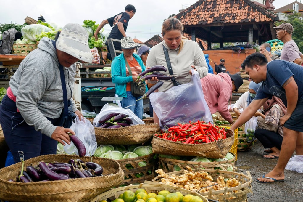 People shop for vegetables at a traditional market in Denpasar, Bali on May 14. Indonesia’s economy posted its slowest growth rate in over three years in the January to March period. Photo: EPA-EFE People shop for vegetables at a traditional market in Denpasar, Bali on May 14. Indonesia’s economy posted its slowest growth rate in over three years in the January to March period. Photo: EPA-EFE