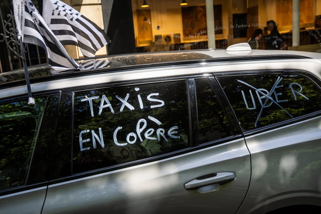 ‘Angry taxis’ is written on a taxi window as taxi drivers block a boulevard near the French Transports Ministry, in Paris on Thursday. Photo: EPA-EFE ‘Angry taxis’ is written on a taxi window as taxi drivers block a boulevard near the French Transports Ministry, in Paris on Thursday. Photo: EPA-EFE