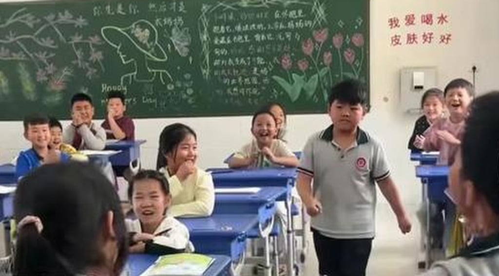 The shy youngster walks up to the front of the class to draw lots as his classmates give him encouragement. Photo: 163.com The shy youngster walks up to the front of the class to draw lots as his classmates give him encouragement. Photo: 163.com