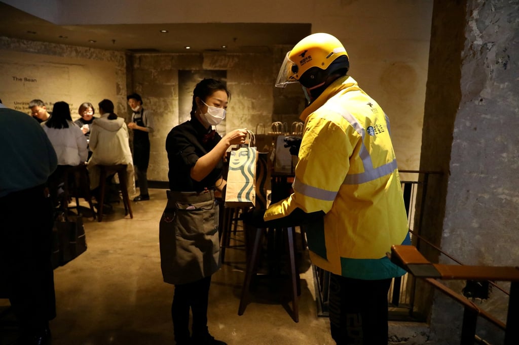 A Meituan delivery worker seen at a Starbucks store in Beijing. Photo: Reuters