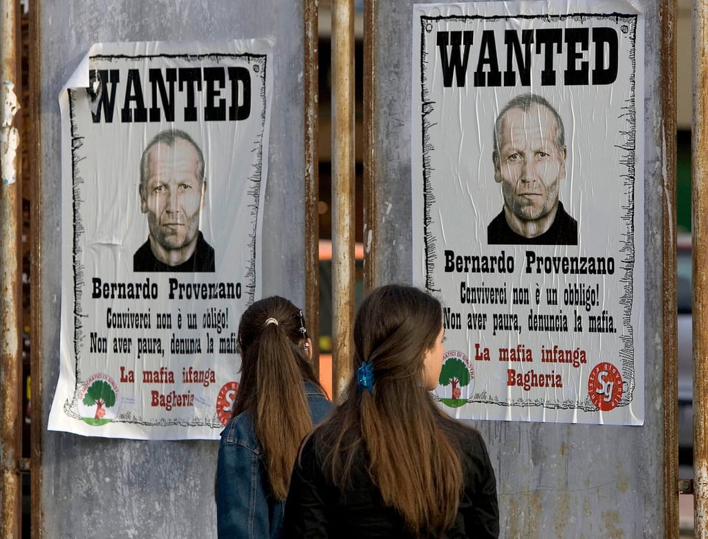 Two girls view posters of the Sicilian Mafia’s top chief Bernardo Provenzano in Palermo in April 2005. Photo: AFP