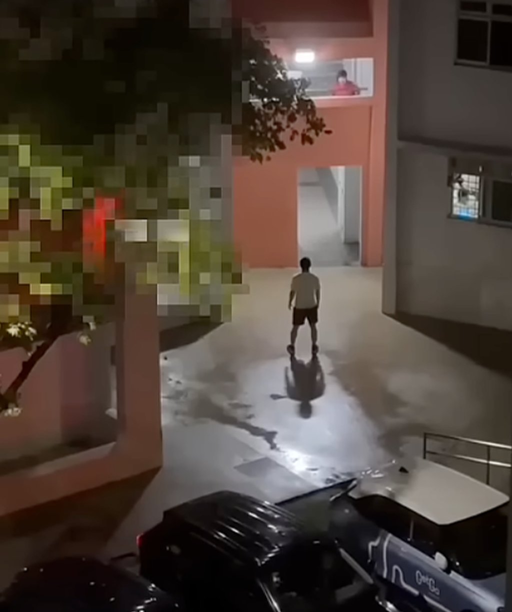 Video footage online shows the man standing near a car park as his wife harangues him from a balcony. Photo: Instagram/tiagong_sg Video footage online shows the man standing near a car park as his wife harangues him from a balcony. Photo: Instagram/tiagong_sg