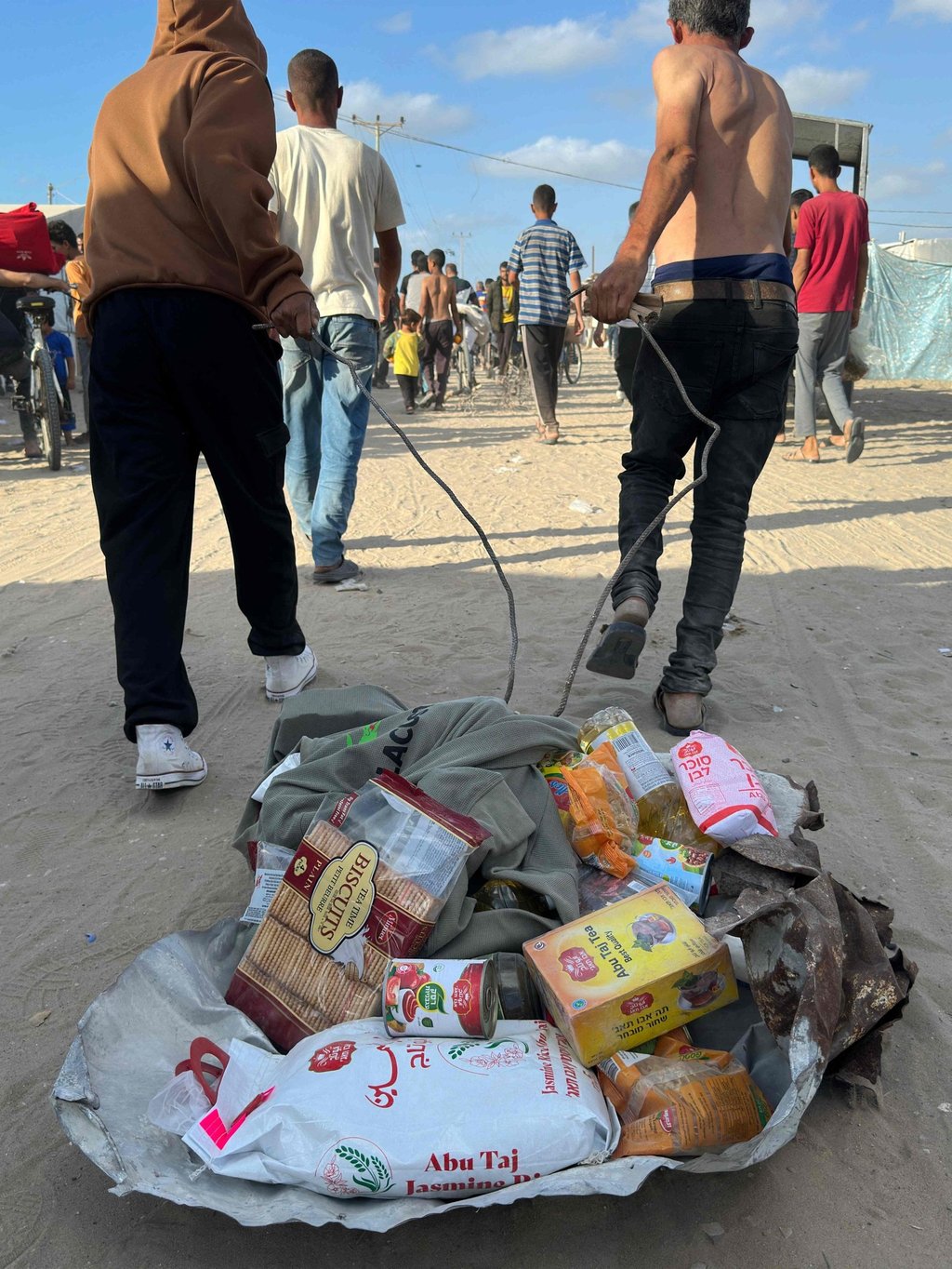 Displaced Palestinians with food packages. Photo: AFP