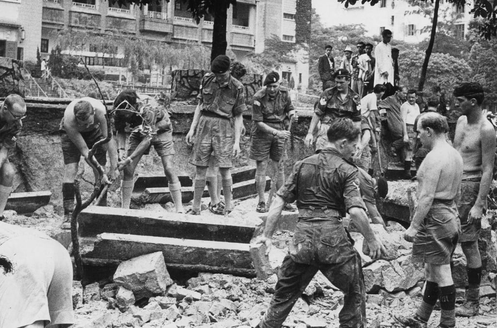 Troops, passersby, firemen and police dig through rubble on Boundary Street after a concrete wall collapsed on a bus queue during heavy rain in 1966. Photo: SCMP Archives