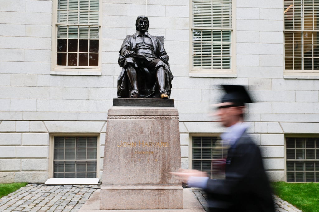 A student walks past the statue of John Harvard on campus. The revocation announced on May 22 was an escalation of the Trump administration’s attack on the university. Photo: Reuters