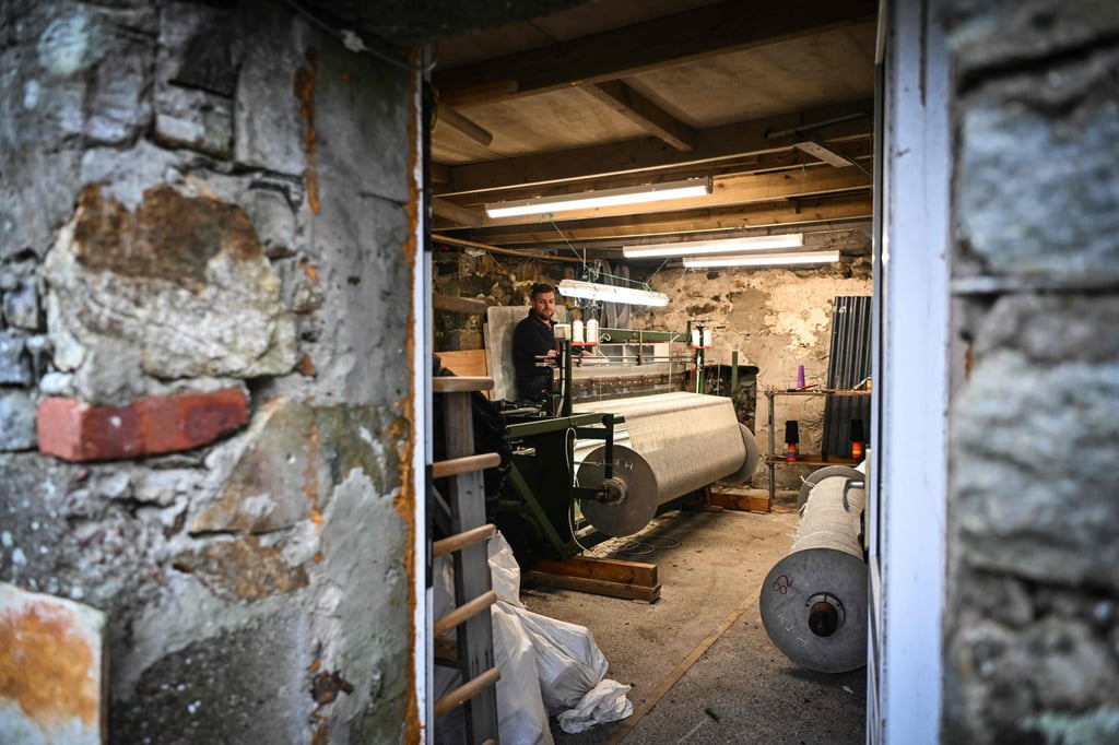 MacLeod works at his weaving loom at his home. Photo: AFP MacLeod works at his weaving loom at his home. Photo: AFP