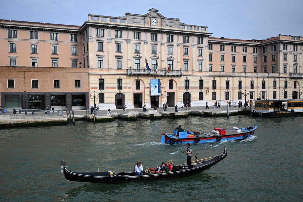 Tourists sail on a gondola along a canal in Venice. Photo: AFP