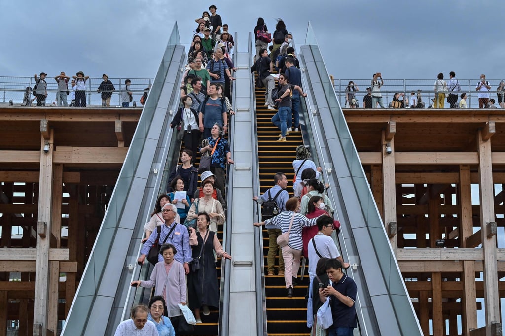 People ride one of the outdoor escalators at the 2025 Osaka Expo on May 21. Escalator etiquette in Japan requires users to stand on one side to allow others in a hurry to walk up the free side of the escalator. Photo: AFP People ride one of the outdoor escalators at the 2025 Osaka Expo on May 21. Escalator etiquette in Japan requires users to stand on one side to allow others in a hurry to walk up the free side of the escalator. Photo: AFP