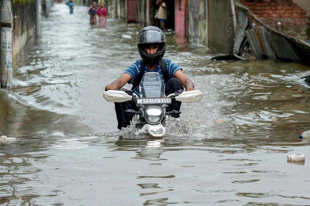 A motorcyclist wades through a flooded street after heavy rains in Guwahati, in India’s Assam state, on Saturday. Photo: AFP