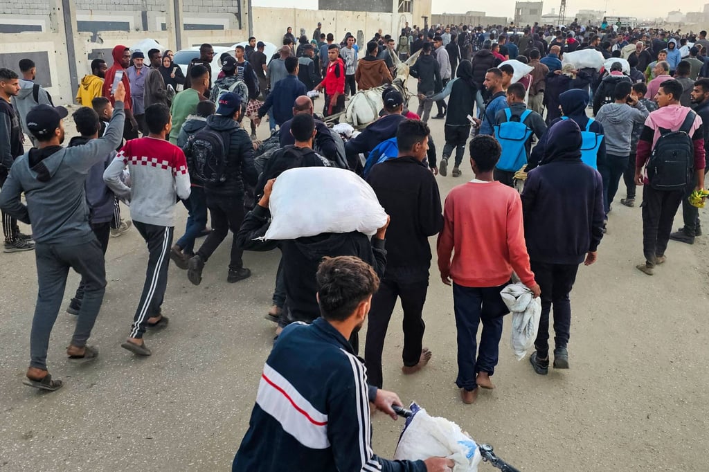 Displaced Palestinians, some carrying sacks of food, leave a distribution centre in Rafah, in the southern Gaza Strip on Sunday. Photo: AFP Displaced Palestinians, some carrying sacks of food, leave a distribution centre in Rafah, in the southern Gaza Strip on Sunday. Photo: AFP
