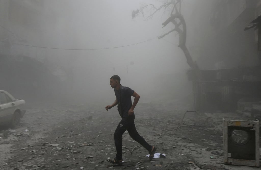 A Palestinian runs after an Israeli strike on a house in Gaza City. Photo: Reuters A Palestinian runs after an Israeli strike on a house in Gaza City. Photo: Reuters