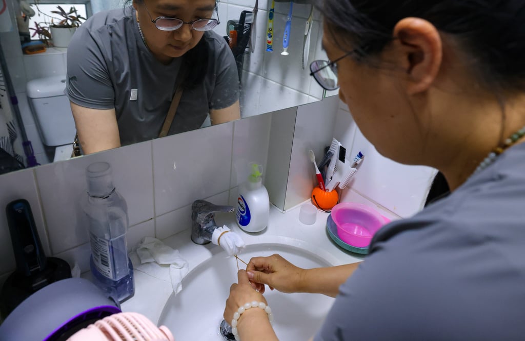 A resident wraps the water faucet with tissue to filter black particles. Photo: Nora Tam A resident wraps the water faucet with tissue to filter black particles. Photo: Nora Tam