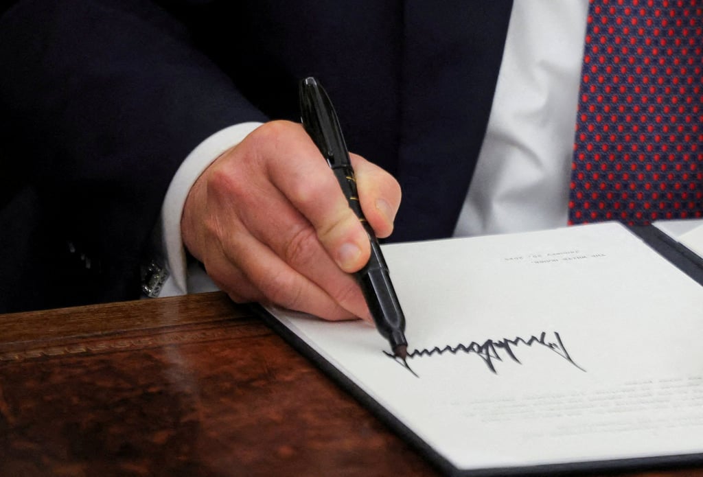 US President Donald Trump signing documents. File photo: Reuters