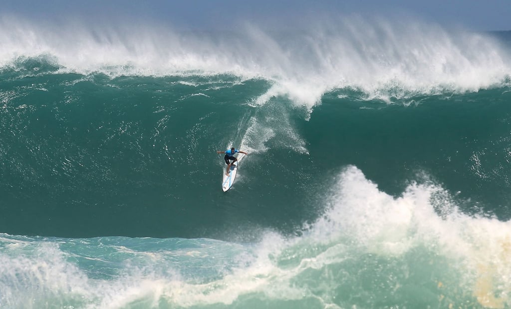 Flores rides a monster wave during the first round of The Quiksilver in Memory of Eddie Aikau invitational at Waimea Bay in Waimea, Hawaii on February 25, 2016. Photo: AFP