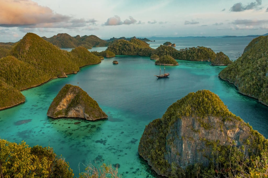 A phinisi dwarfed by islands in Indonesia’s Raja Ampat archipelago, in the Pacific. Photo: Shutterstock