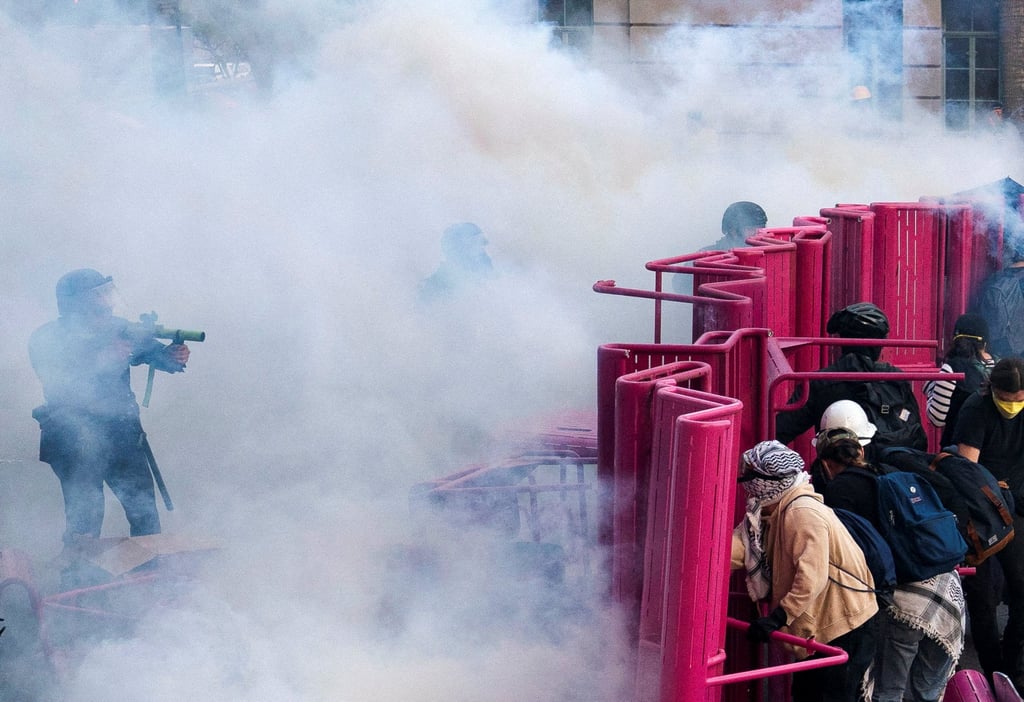 Police move to clear demonstrators blocking a street with a barricade. Photo: Reuters Police move to clear demonstrators blocking a street with a barricade. Photo: Reuters