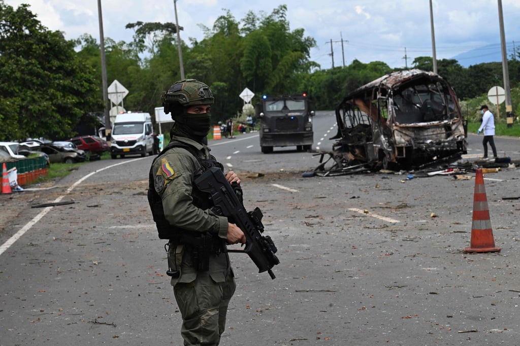 A police officer stands guard at the site where a bus exploded in front of a police station in Villa Rica in Colombia on Tuesday. Photo: AFP A police officer stands guard at the site where a bus exploded in front of a police station in Villa Rica in Colombia on Tuesday. Photo: AFP