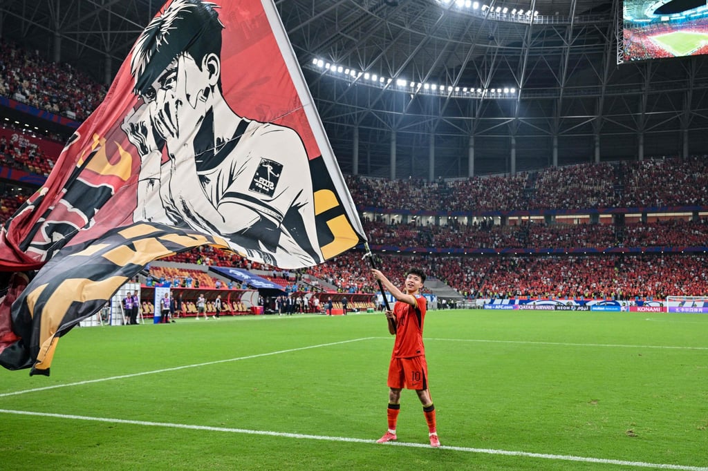 China’s Wang Yudong waves a flag in front of fans after the team’s win against Bahrain. Photo: AFP China’s Wang Yudong waves a flag in front of fans after the team’s win against Bahrain. Photo: AFP