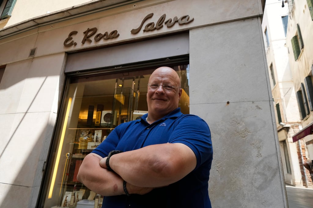 Pastry shop owner Andrea Rosa Salva poses outside his shop in Venice on June 12. Photo: AP