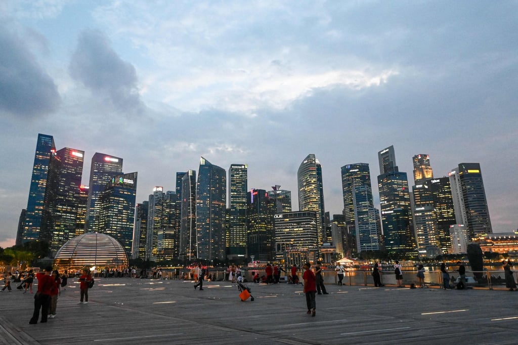 People gather along the boardwalk in front of the skyline at Marina Bay in Singapore. Photo: AFP People gather along the boardwalk in front of the skyline at Marina Bay in Singapore. Photo: AFP