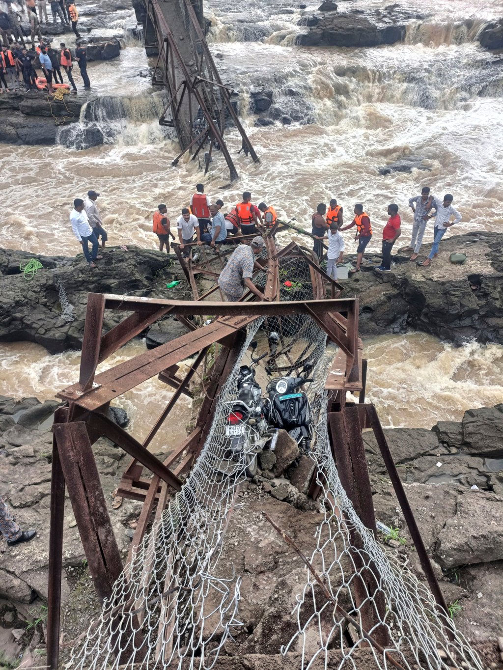 Rescuers work at the site of the bridge collapse near Pune on Sunday. Photo: AP Photo