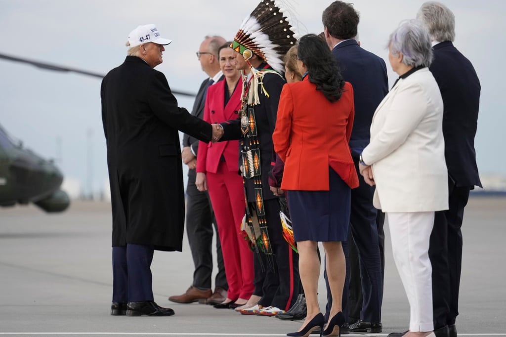 US President Donald Trump being greeted on the tarmac. Photo: AP