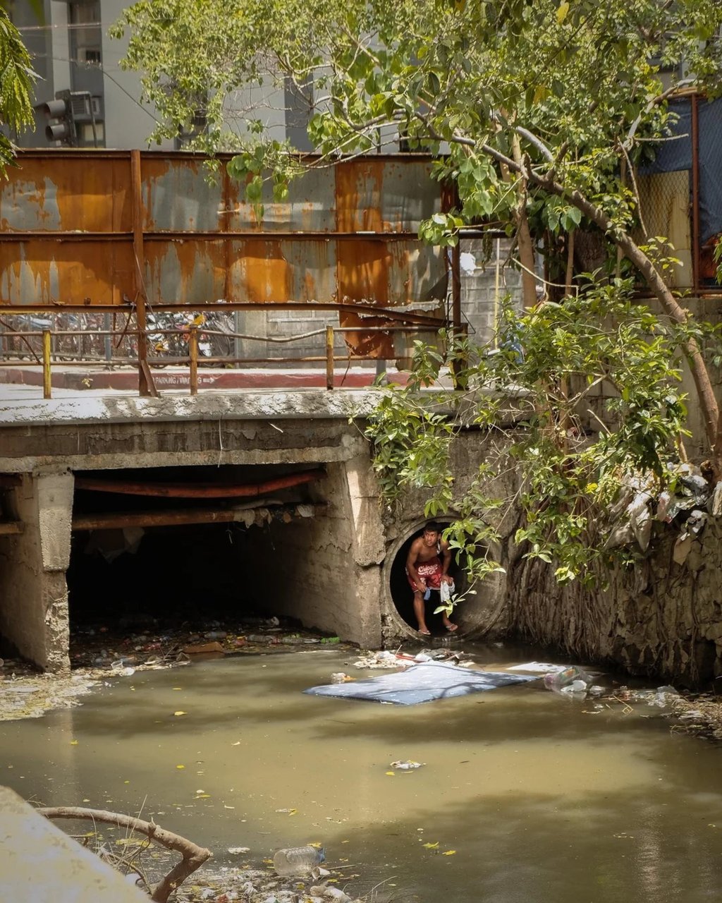 A man climbs out of a culvert in a creek in Makati City, apparently home to a small community of street dwellers in the Philippines. Photo: William Roberts A man climbs out of a culvert in a creek in Makati City, apparently home to a small community of street dwellers in the Philippines. Photo: William Roberts