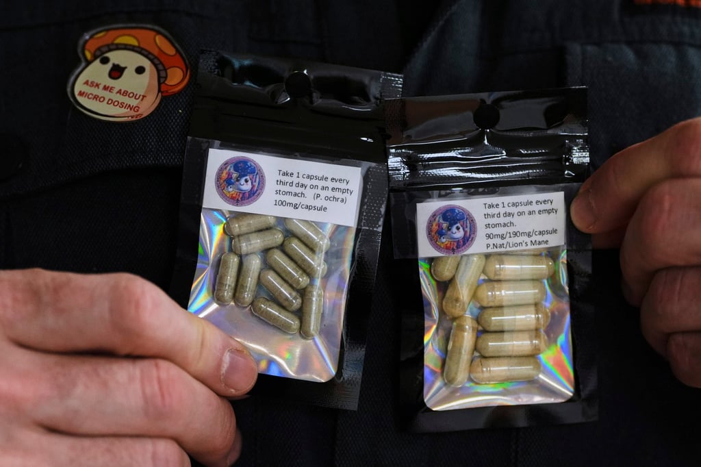 A man in the US who grows his own mushrooms for microdosing psilocybin displays prepared doses in packets earlier this year. Photo: AP
